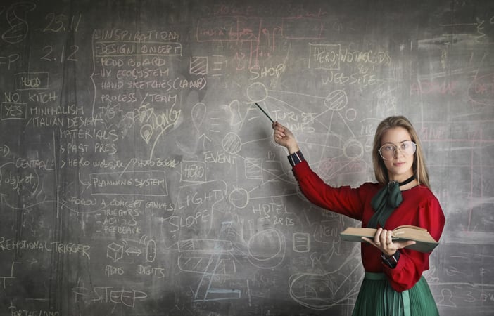 teacher pointing on black board