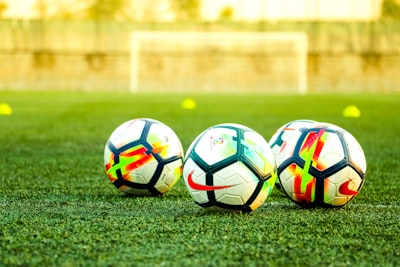 3 white footballs in playground
