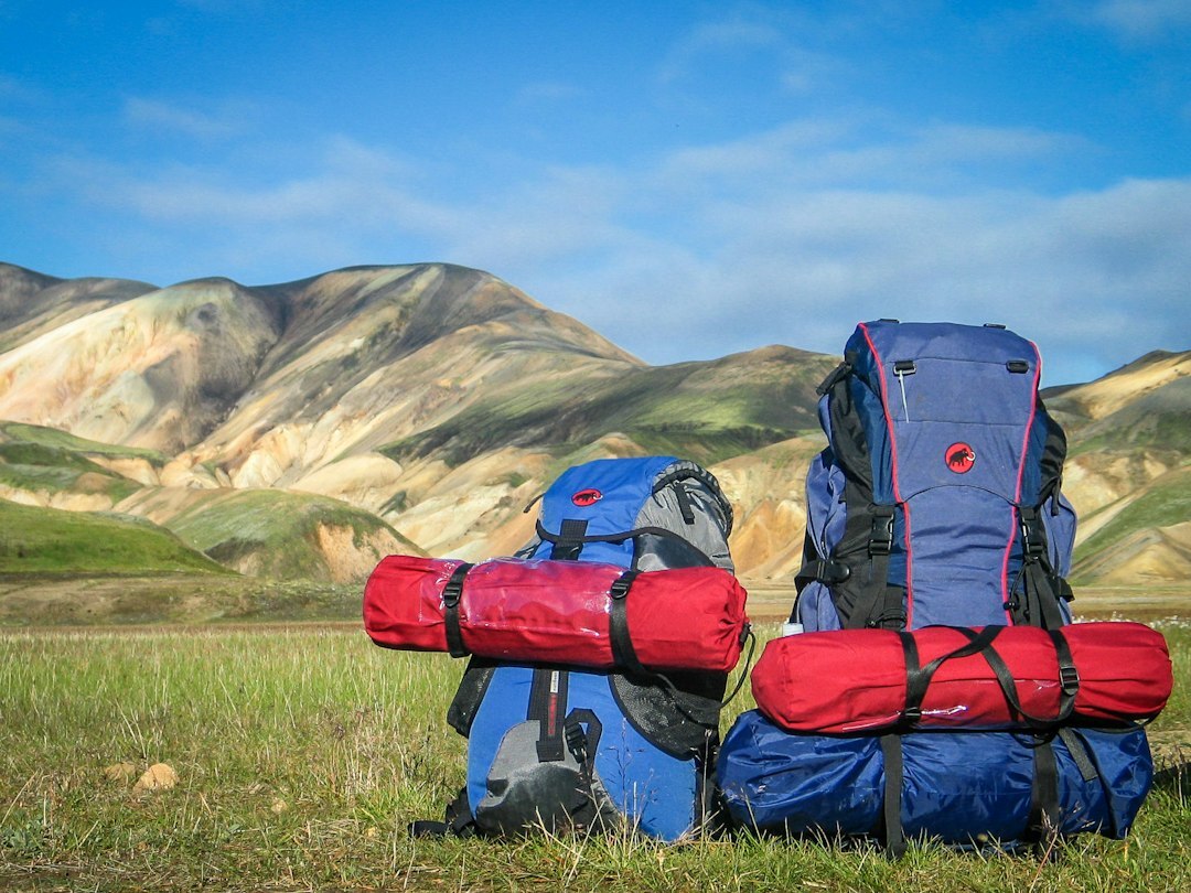 Blue waterproof hiking backpacks with red roll bags